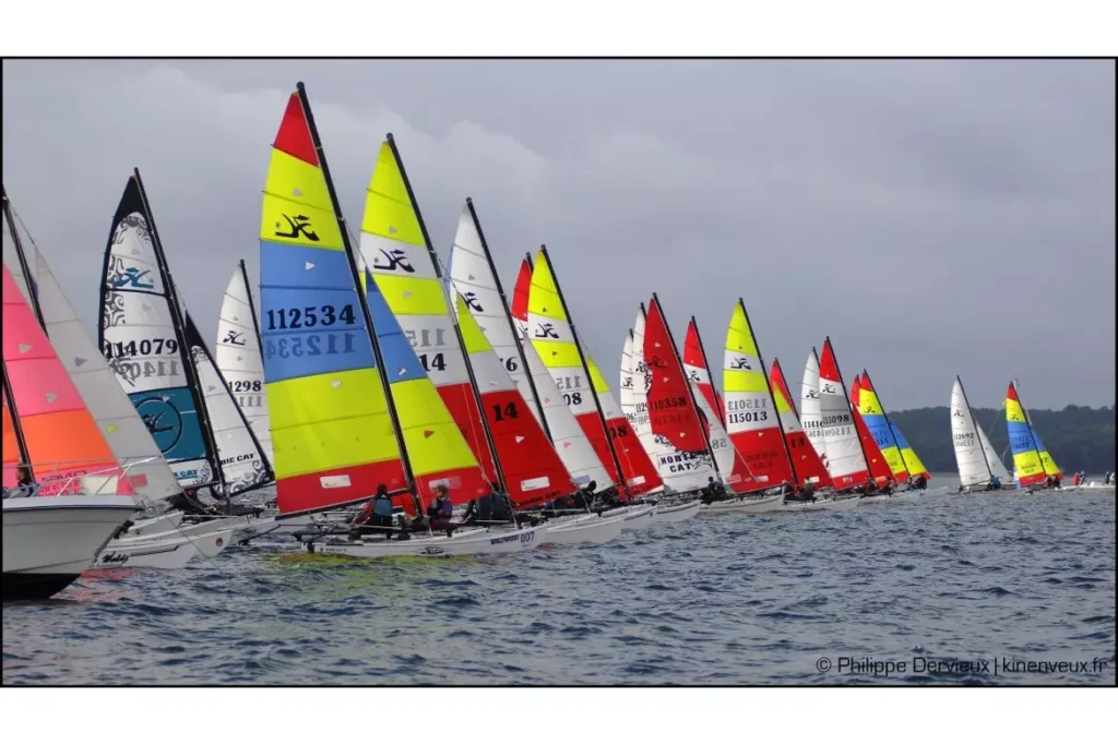 Régate de catamarans Hobie Cat aux voiles colorées, numéros 112534 et 114079, compétition de voile en mer.